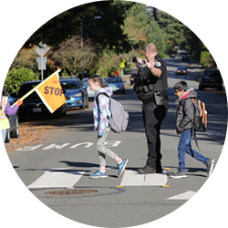 A crossing guard helping kids get to school.