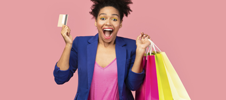 Woman holding shopping bags and a credit card.