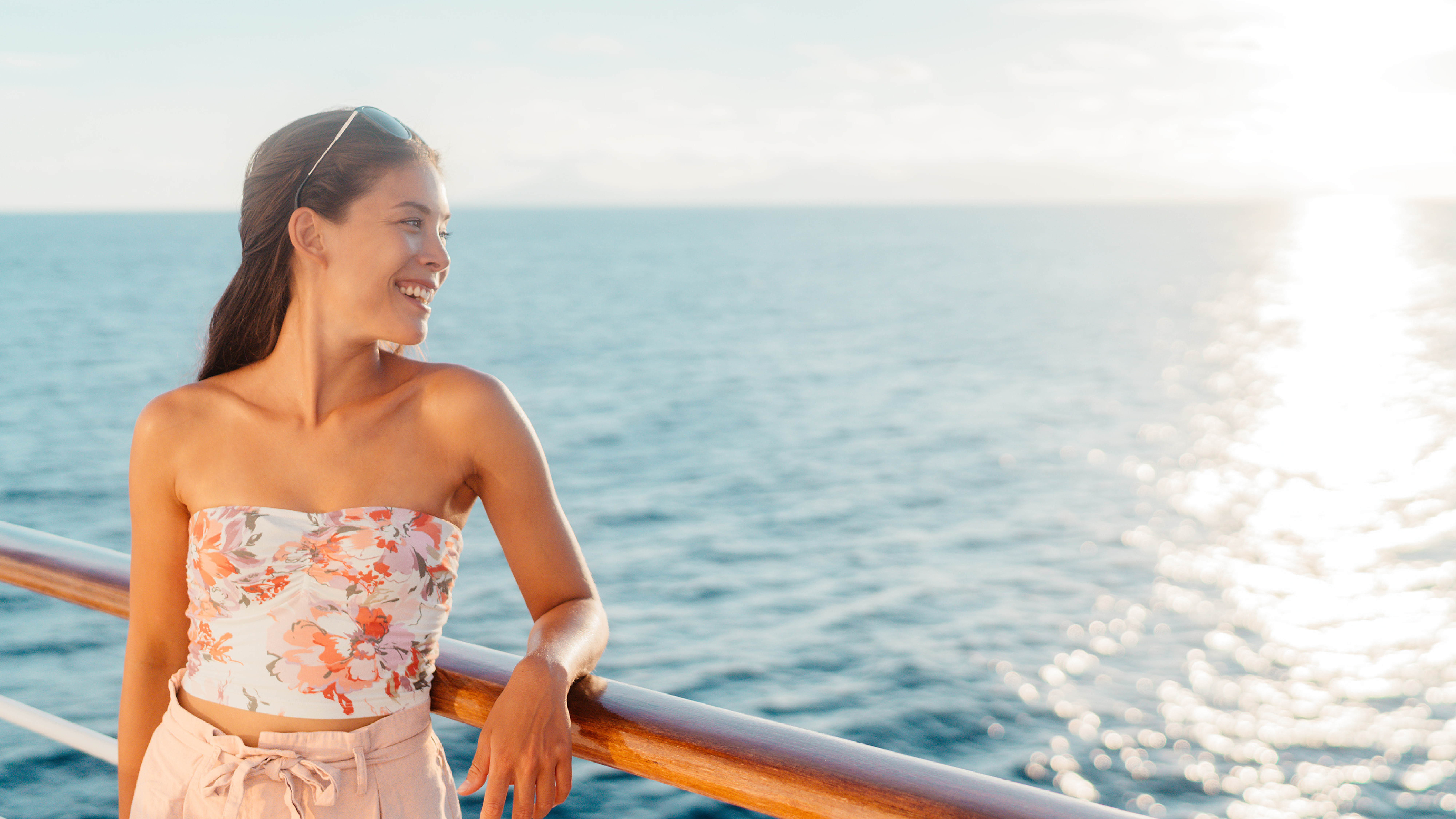 Woman overlooking ocean from railing of cruise ship